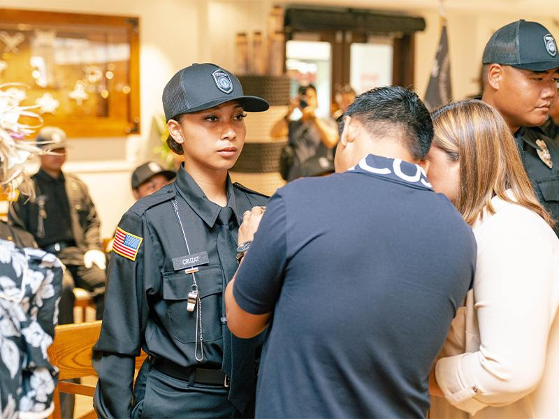 9th Cycle Corrections Academy salutatorian Daphne I. Cruzat's father pins a badge on her uniform during the graduation ceremony on Thursday, Oct. 6, 2022 at the Pacific Islands Club.